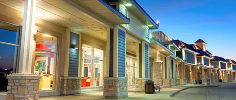 Exterior storefront of Doctor's Choice dental practice at dusk with illuminated windows and professional signage.