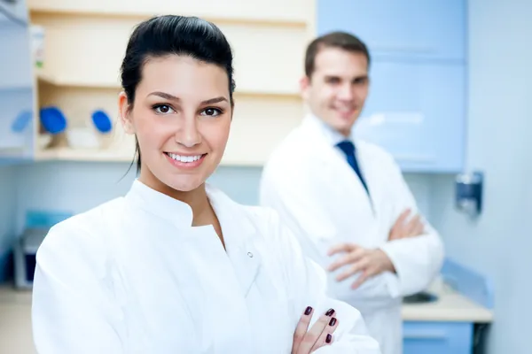 Doctor's Choice dental team: female dentist in white coat with male colleague in modern office.
