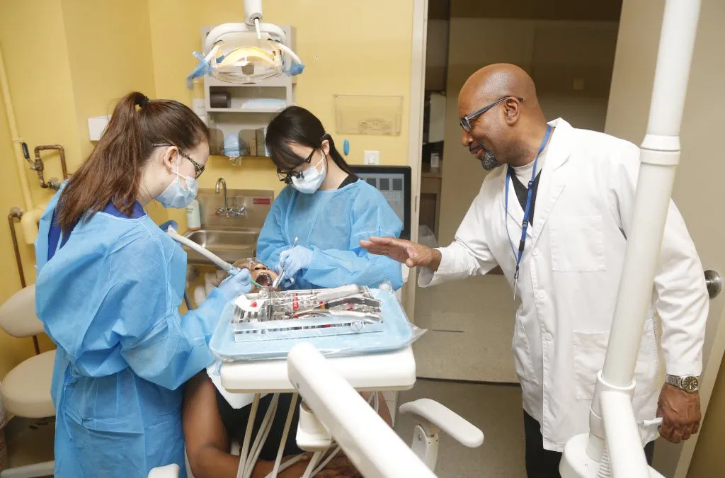 Doctor's Choice dental team in treatment room with dentist instructing assistants on instruments